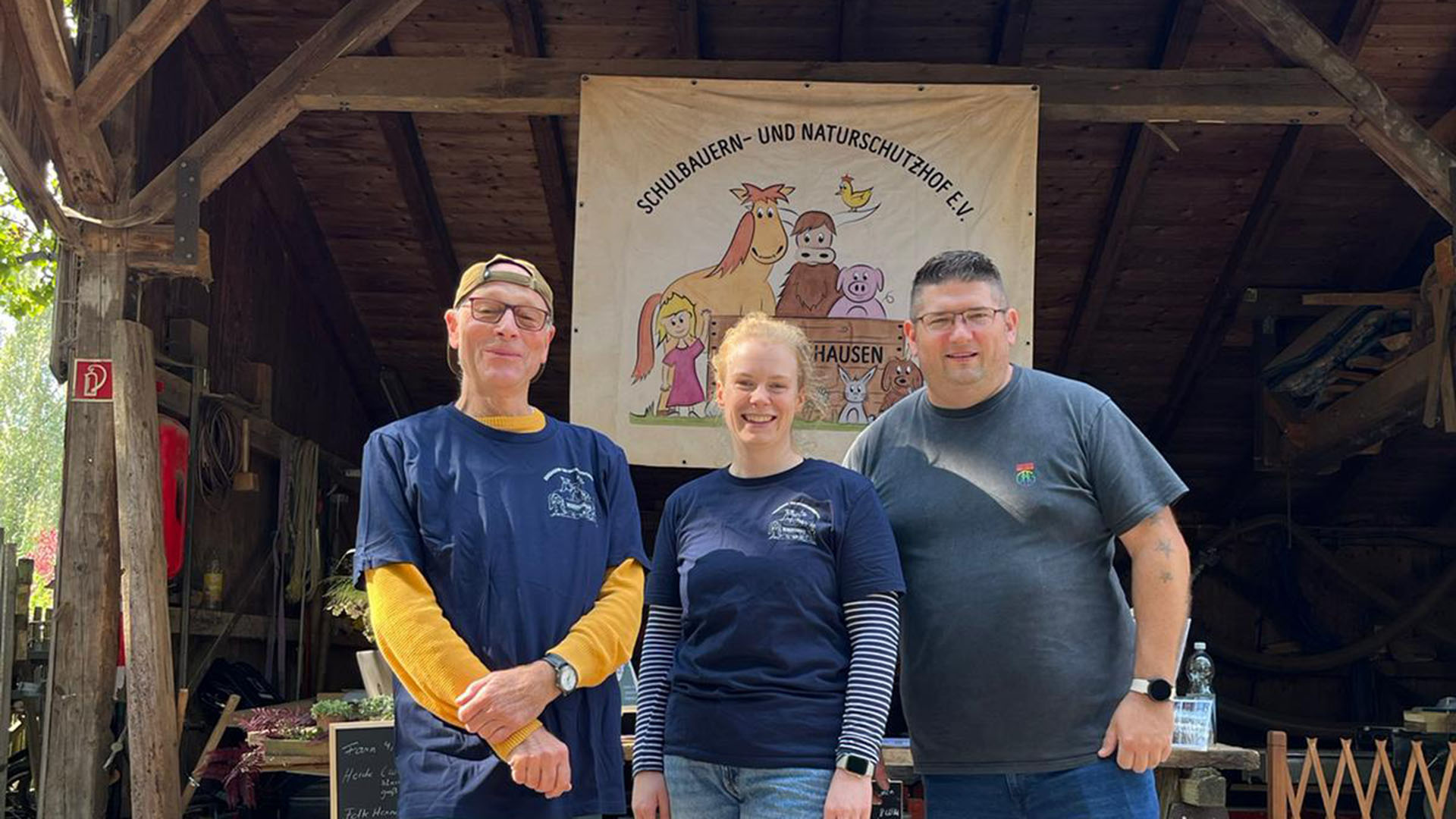 Drei Menschen blicken lächelnd in die Kamera.